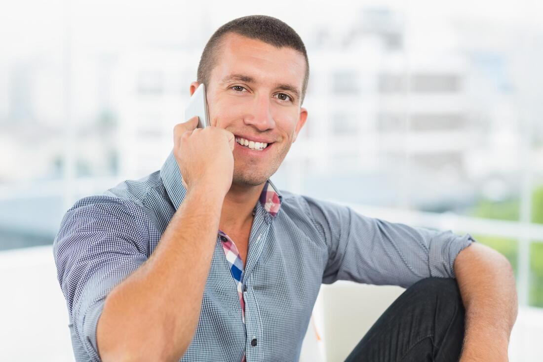 man smiling taking phone call